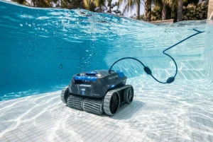 Robot nettoyeur de piscine télécommandé sous l’eau, câble et tapis de filtration visibles, plongé dans une piscine claire. Meilleur robot nettoyeur de piscine.